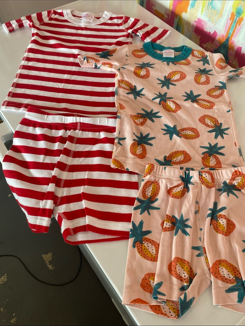 2 pairs Hanna Andersson knit pjs. Red Striped & Peach Pineapple. Good condition